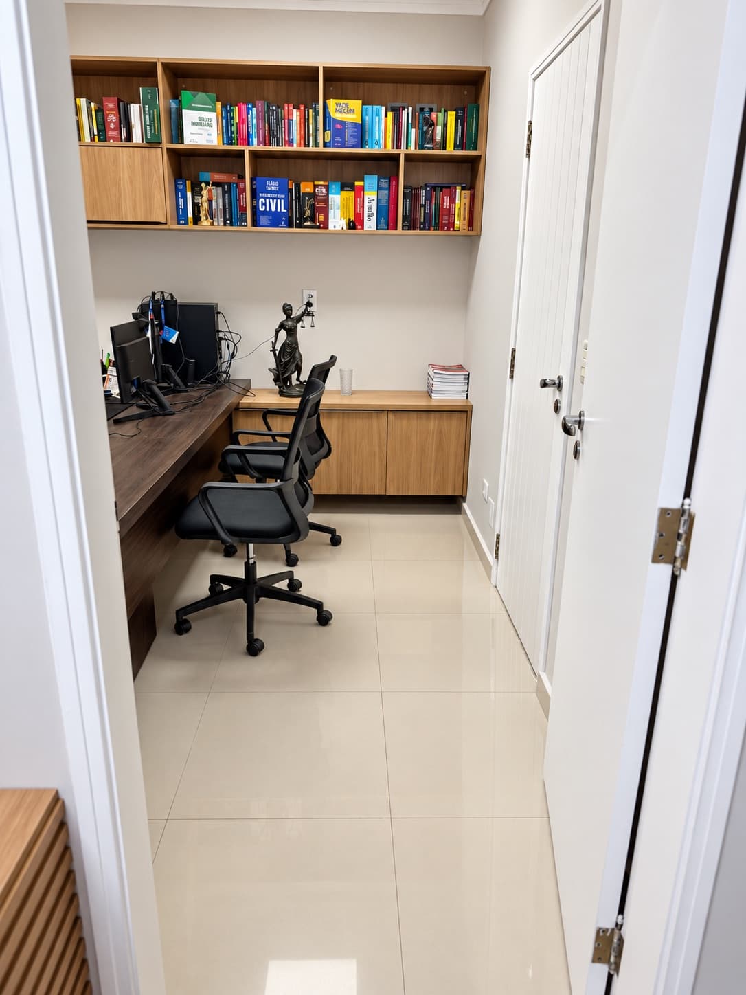 Ambiente de trabalho com biblioteca jurídica e estação de atendimento